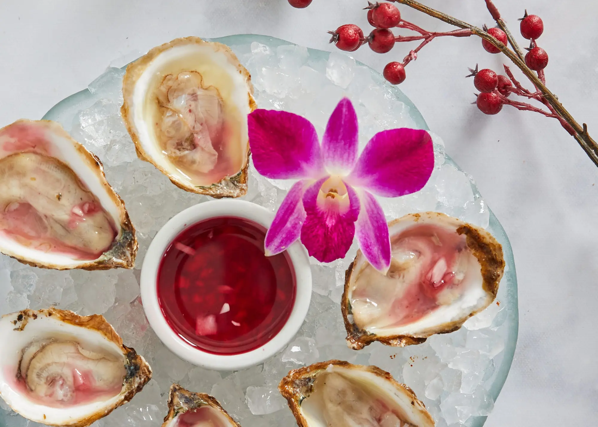 Oysters on ice around a mignonette, an orchid in the middle